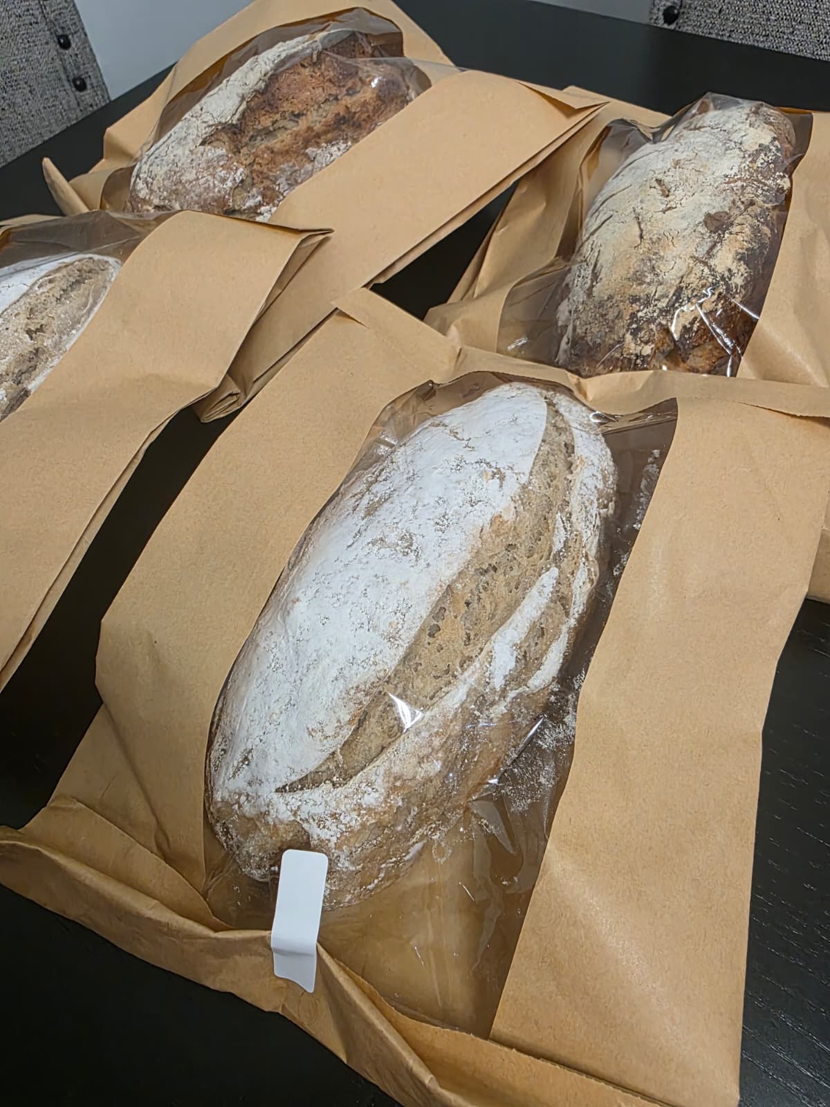 Artisan loaves wrapped in paper bakery bags